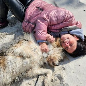 Sabina und Hund Fiene liegen am Strand